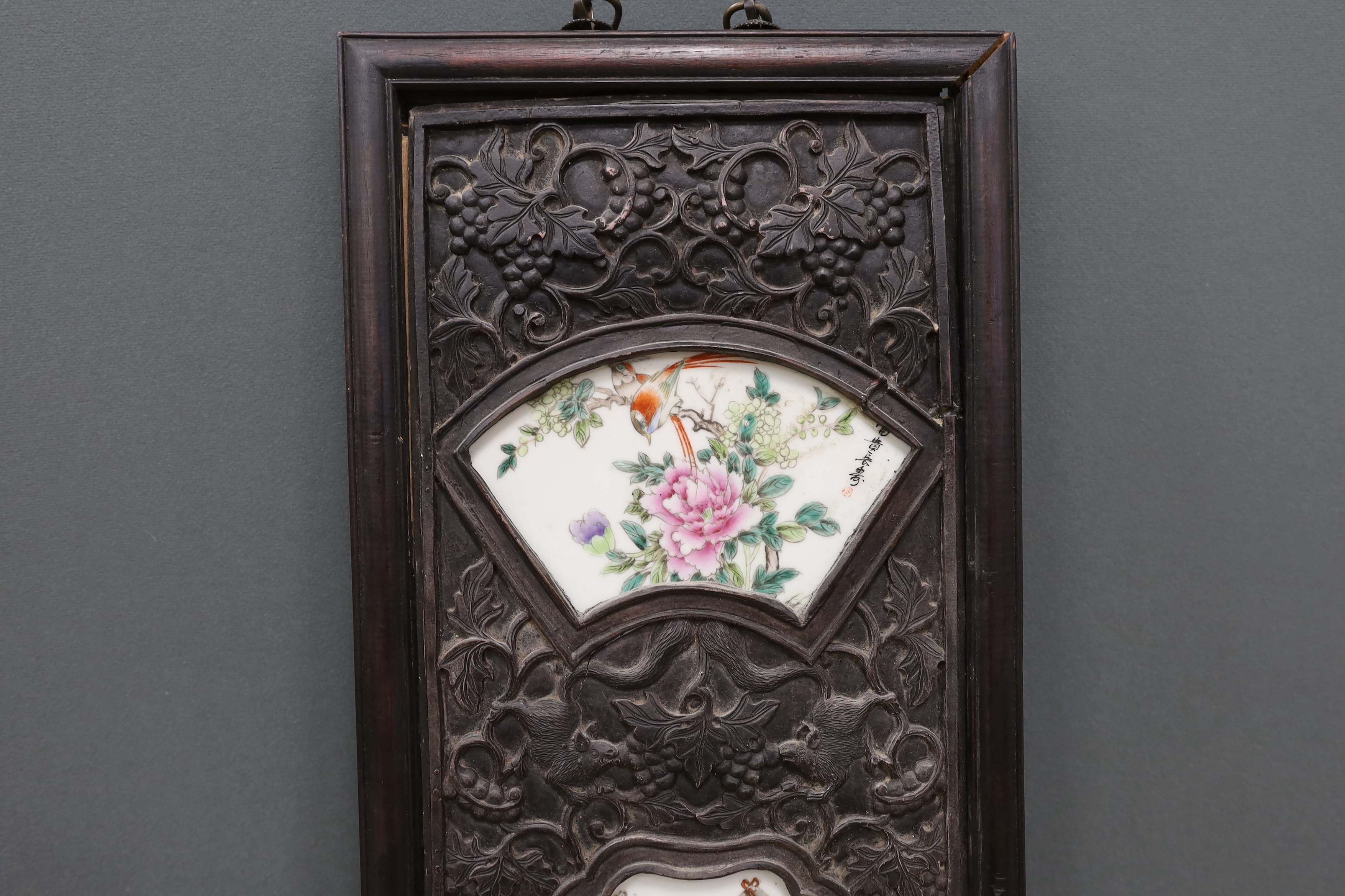 A Chinese famille rose porcelain panel, housed in a carved hardwood frame, 106cm high